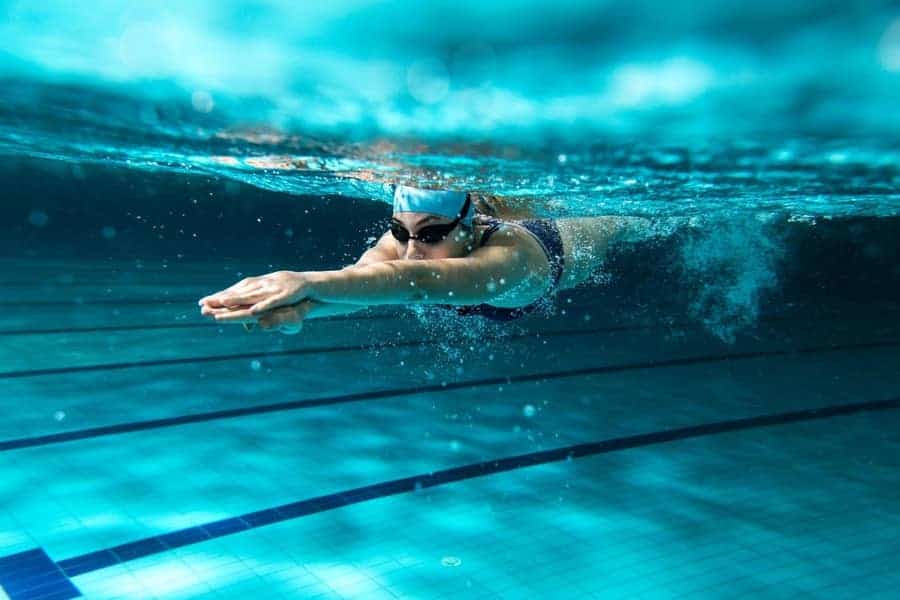 Female swimmer at the swimming pool. Underwater photo. 