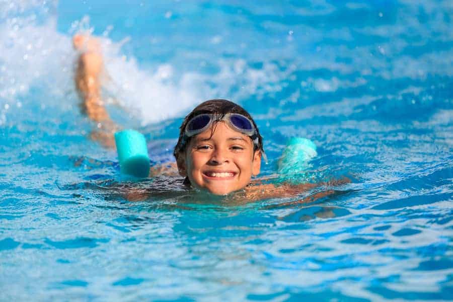 Happy boy swimming in a swimming pool